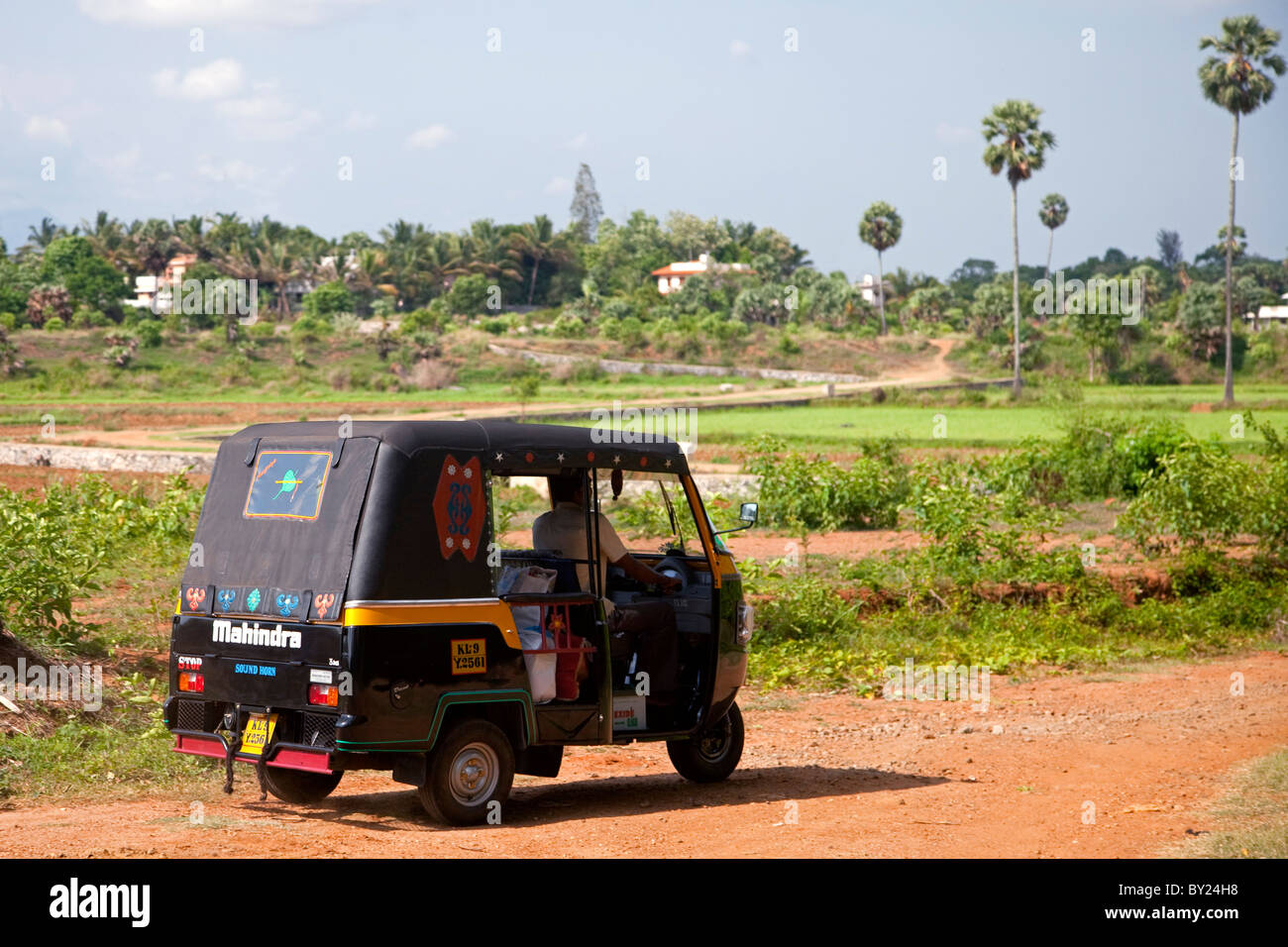 India, Palakkad. Un tuk tuk aziona attraverso il paesaggio rurale vicino a Palakkad. Foto Stock