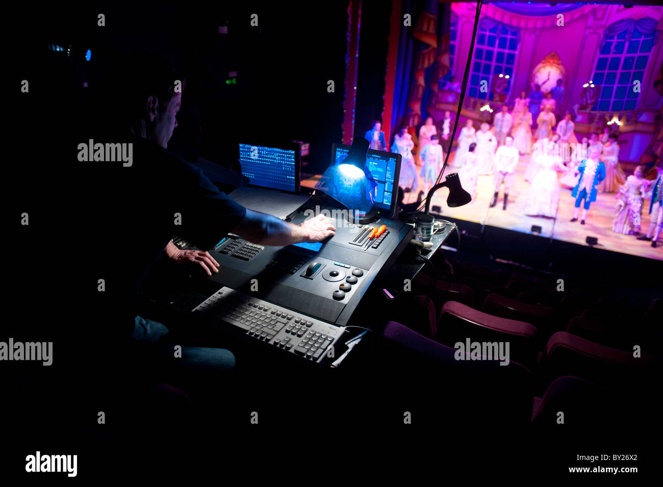 Un uomo alla guida di una illuminazione digitale scheda desk in un teatro, disegnando le luci per una fase di produzione, REGNO UNITO Foto Stock