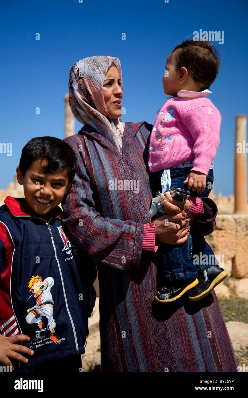 Sabratha, Libia; una donna musulmana velata con i suoi figli tra i resti di antiche città romane che giace appena fuori la Foto Stock