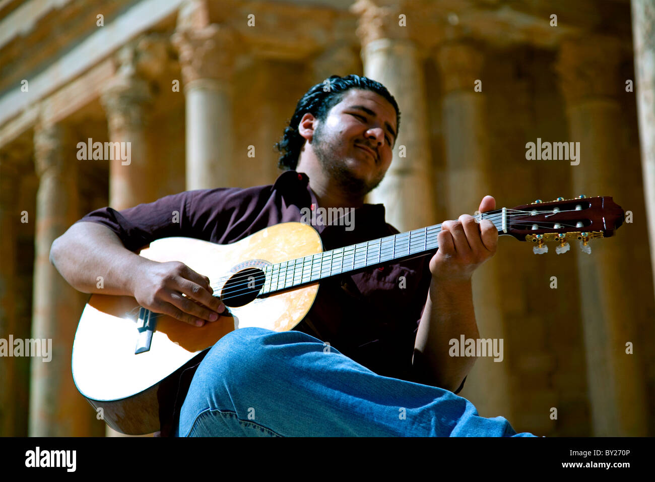 Sabratha, Libia; un giovane chitarrista giocare davanti al teatro rimane a Sabrata Foto Stock