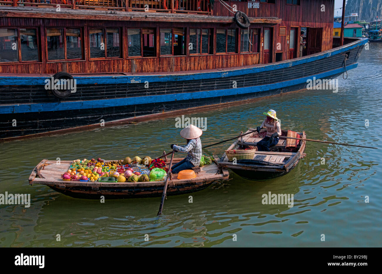 Donna del fornitore per la vendita di frutta Halong Bay Ha Long a diportisti come rilassarsi Vietnam Foto Stock