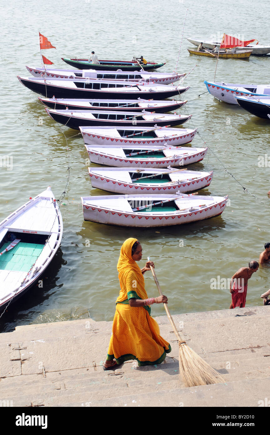 Una donna spazzare i ghats dalle rive del Gange a Varanasi Foto Stock