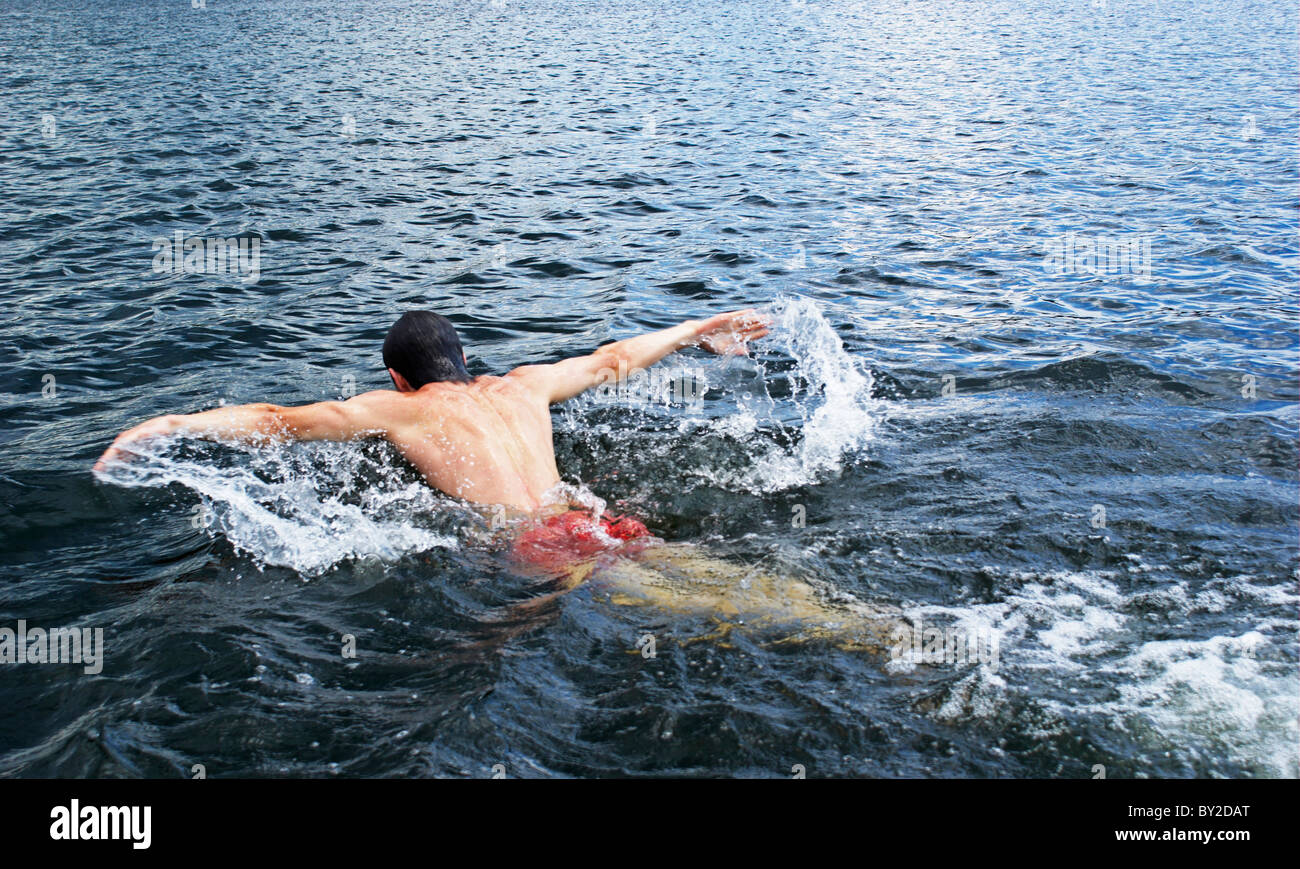 Giovane uomo nuotare nel fiume Foto Stock