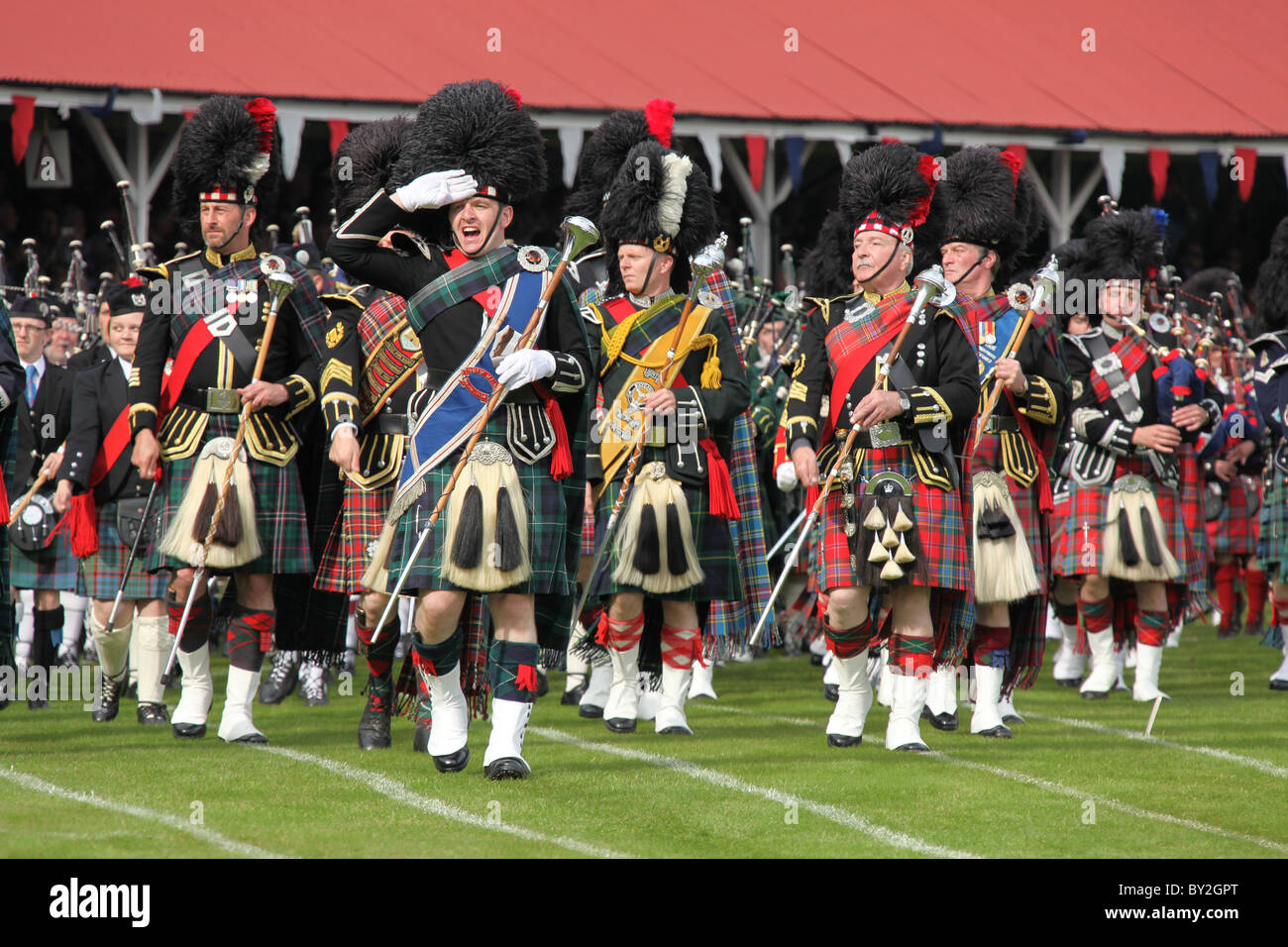 Villaggio di Braemar, Scozia. Il tubo ammassato Marching Band presso il Royal Braemar raccolta di giochi. Foto Stock