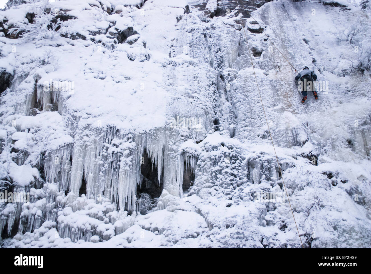 Un alpinista salire una caduta di ghiaccio a Pyhätunturi in Lapponia, Finlandia. Foto Stock