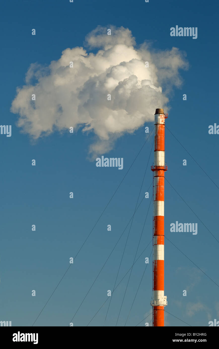 Di fumo, gas e vapore flutti di un fumaiolo contro un cielo blu. Foto Stock