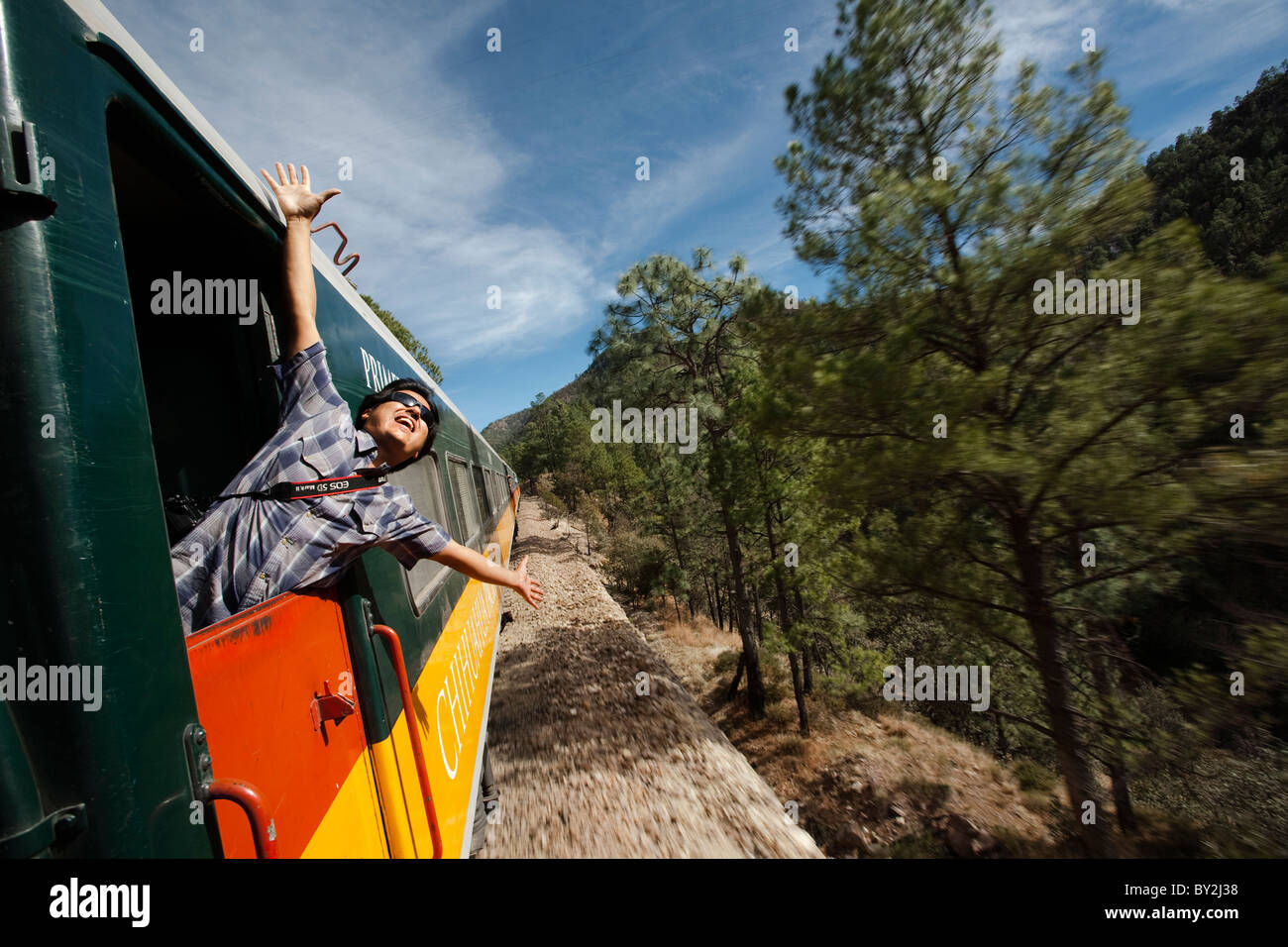 Un uomo sorride braccia aperte in corrispondenza di un treno a Chihuahua, Messico. Foto Stock