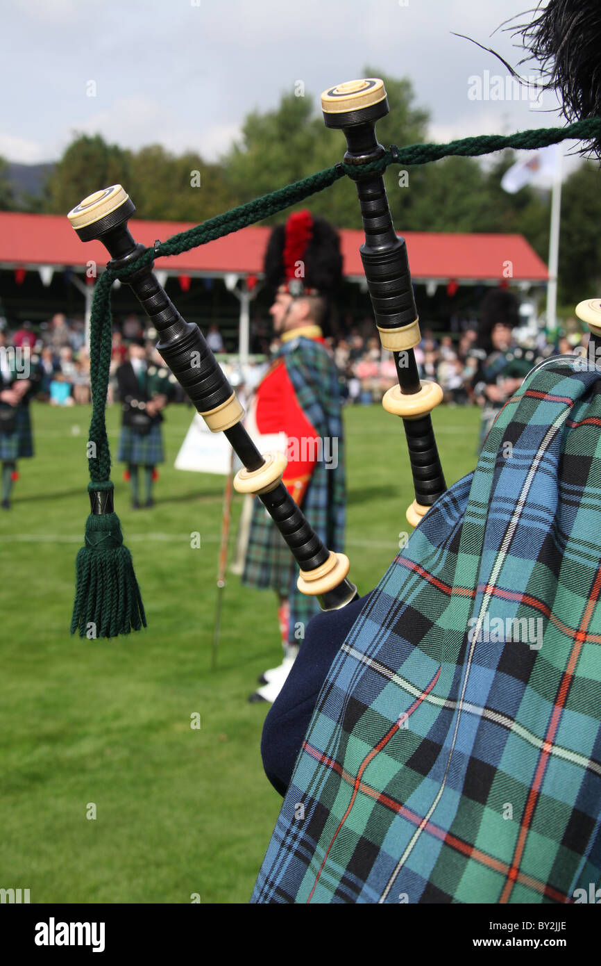 Villaggio di Braemar, Scozia. Vista posteriore di un piper dal Ballater & District Pipe Band a Braemar raccolta di giochi. Foto Stock
