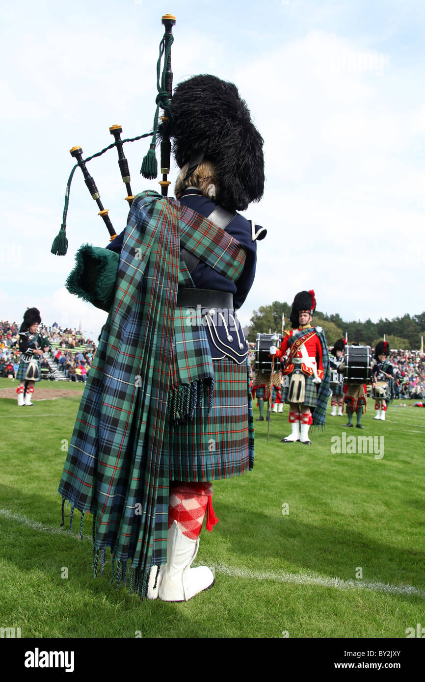Villaggio di Braemar, Scozia. Vista posteriore di un piper dal Ballater & District Pipe Band a Braemar raccolta di giochi. Foto Stock
