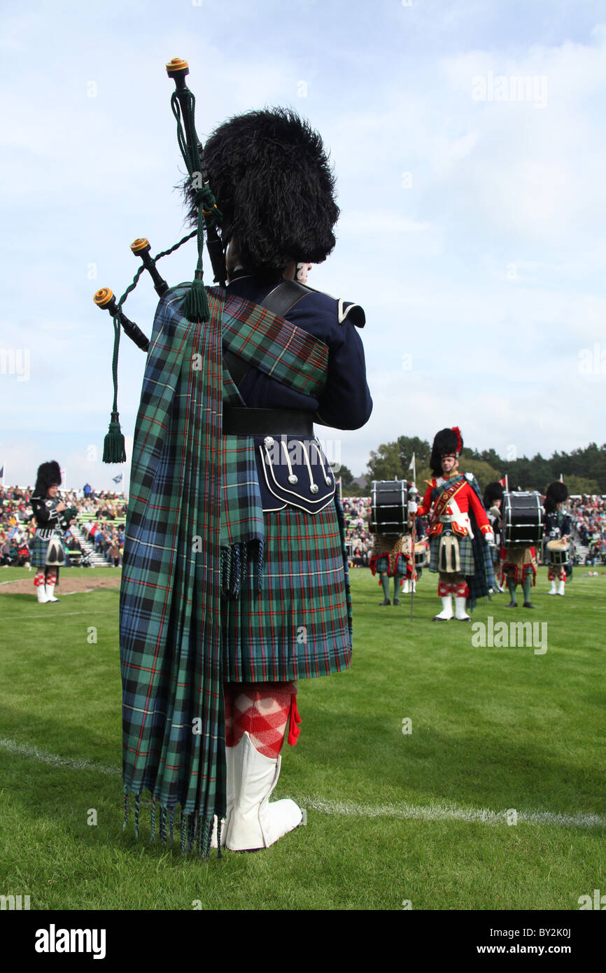 Villaggio di Braemar, Scozia. Vista posteriore di un piper dal Ballater & District Pipe Band a Braemar raccolta di giochi. Foto Stock