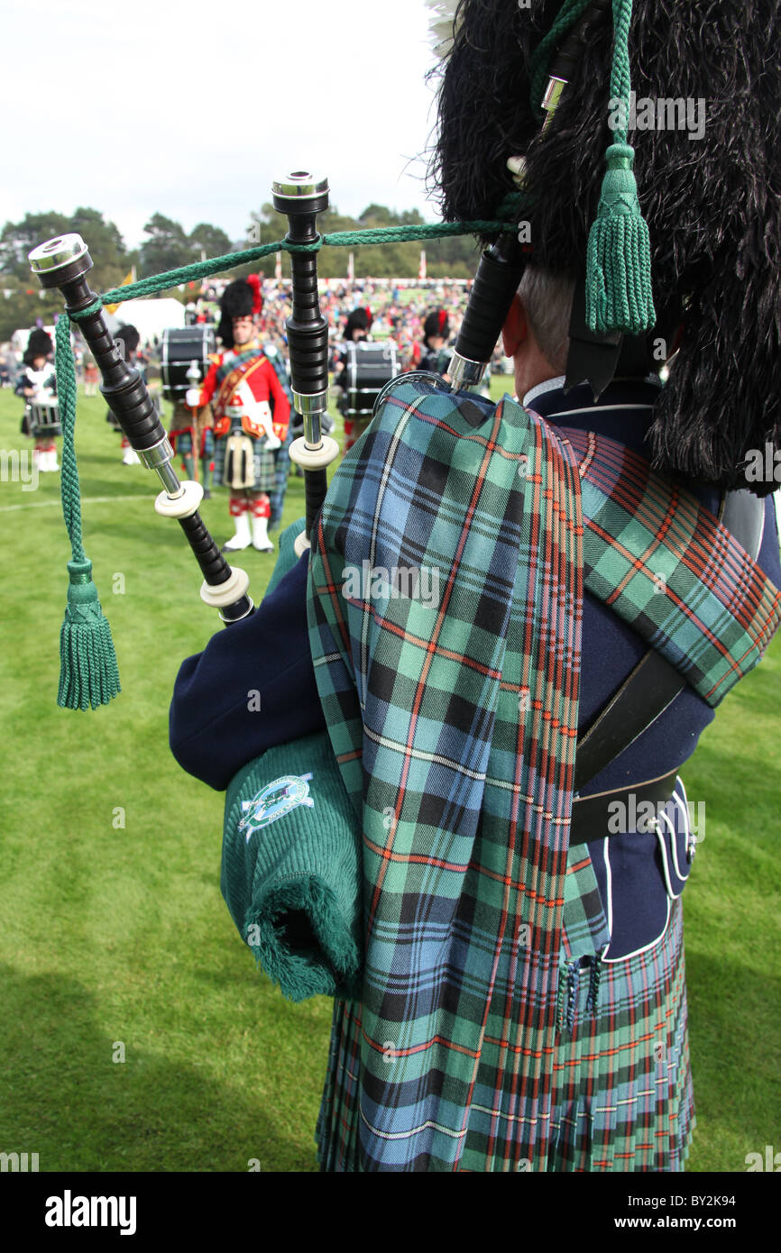 Villaggio di Braemar, Scozia. Vista posteriore di un piper dal Ballater & District Pipe Band a Braemar raccolta di giochi. Foto Stock