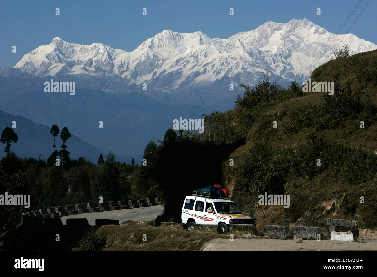 La strada si snoda il modo attraverso l'Himalaya con il Monte Khangchendzonga a Darjeeling, India. Foto Stock