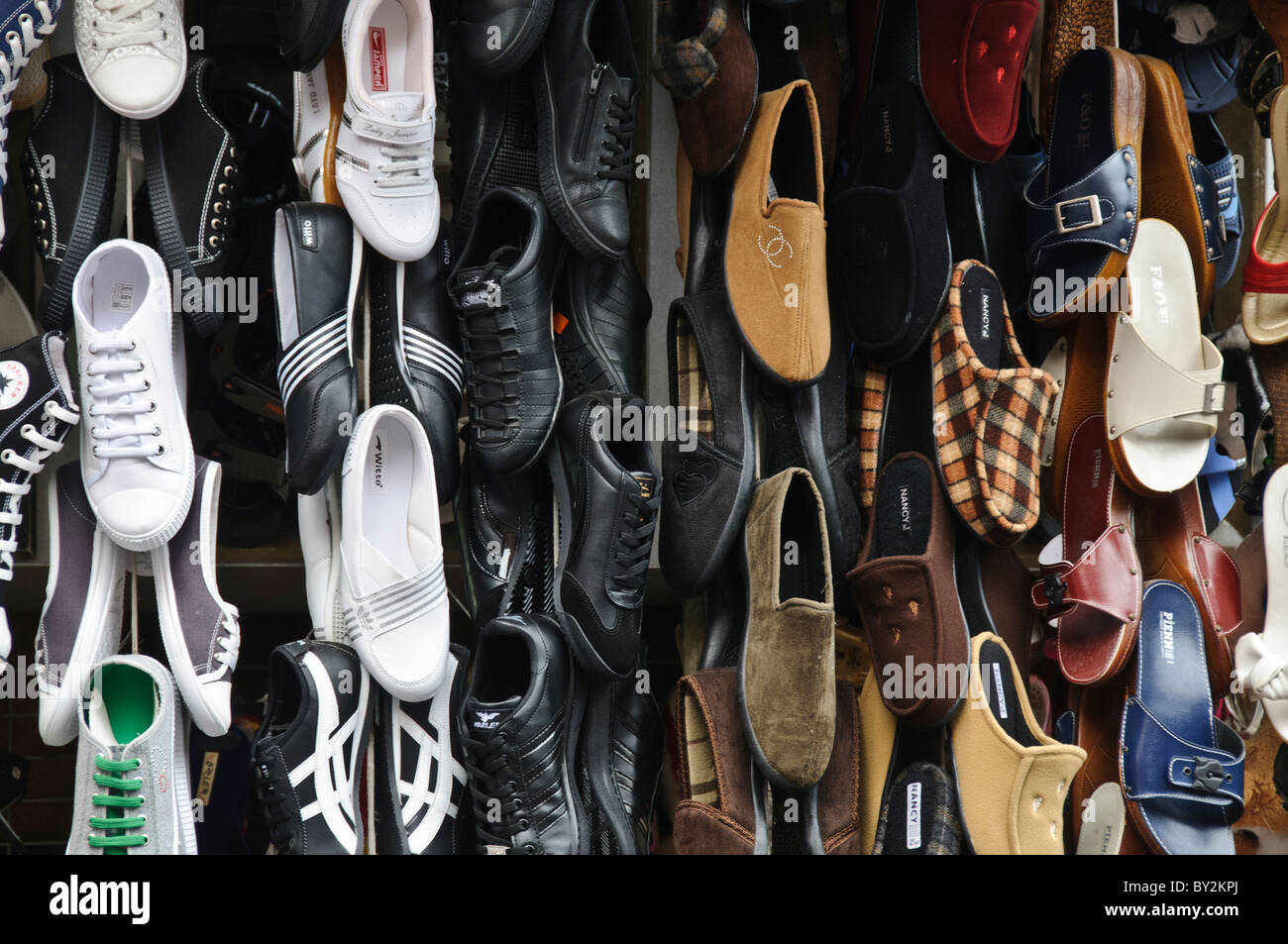 Scarpe in vendita Bazaar delle spezie Istanbul // ISTANBUL, Turchia — Un'esposizione di scarpe da parete in vendita presso il Bazaar delle spezie (noto anche come Bazaar egiziano) di Istanbul. Il Bazar delle spezie è uno dei più antichi mercati coperti di Istanbul, originariamente costruito nel 1664 come parte del complesso della nuova Moschea. Il bazar era storicamente il centro del commercio delle spezie tra Europa e Asia, anche se oggi ospita diversi venditori che vendono di tutto, dai prodotti tradizionali turchi alle calzature. Situato nel quartiere di Eminönü, il mercato a forma di L contiene 88 negozi sotto i suoi soffitti a volta. Il bazar continua a servire bot Foto Stock
