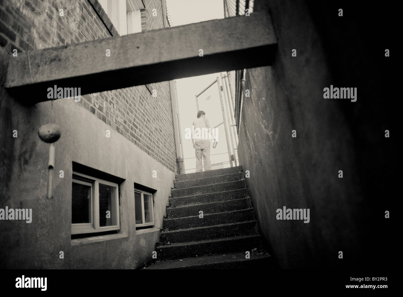 Un giovane senzatetto beve birra in un vicolo nel quartiere universitario di Seattle. Foto Stock