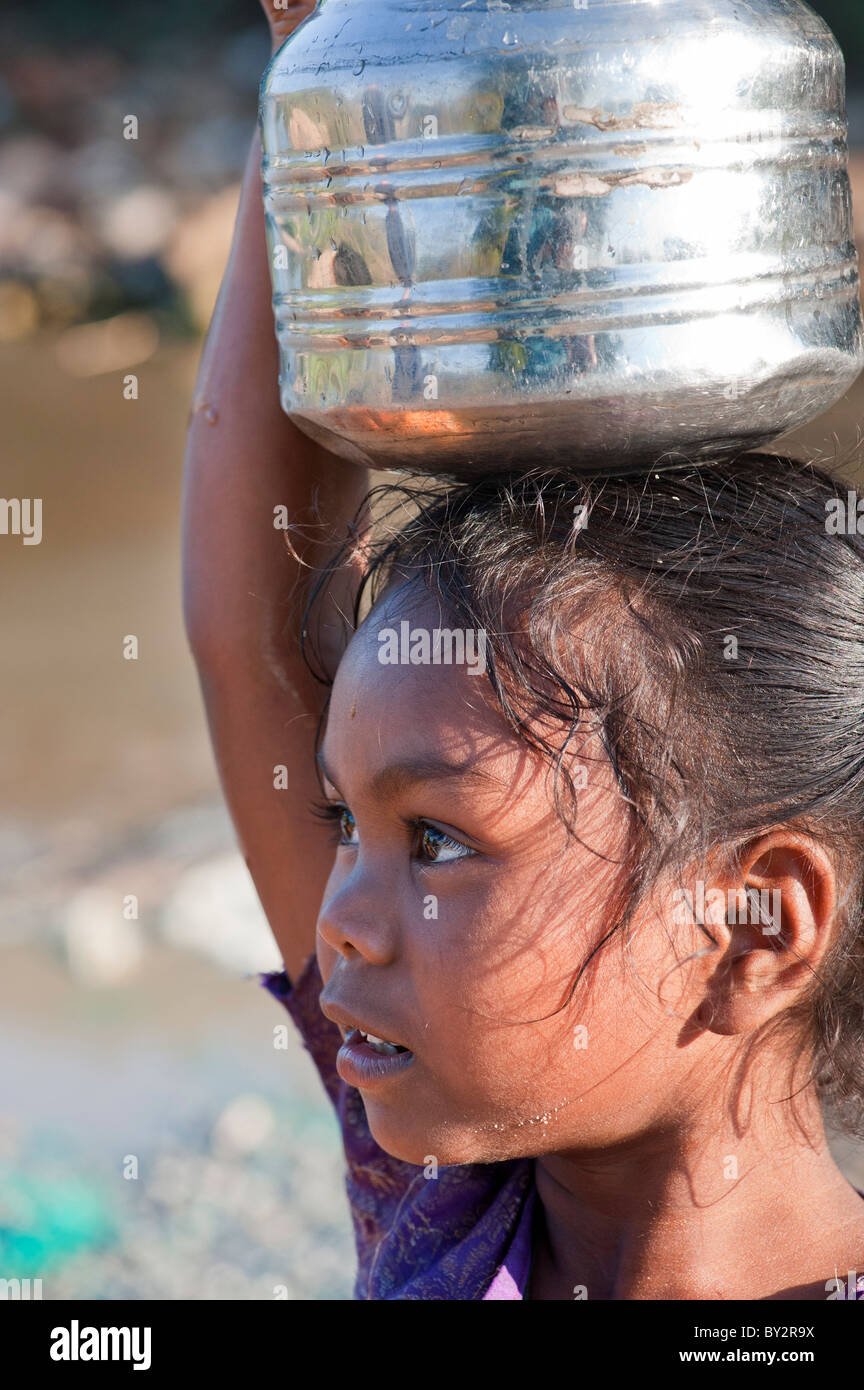 Sorridendo felice villaggio indiano ragazza che porta una pentola d'acqua. Andhra Pradesh, India Foto Stock