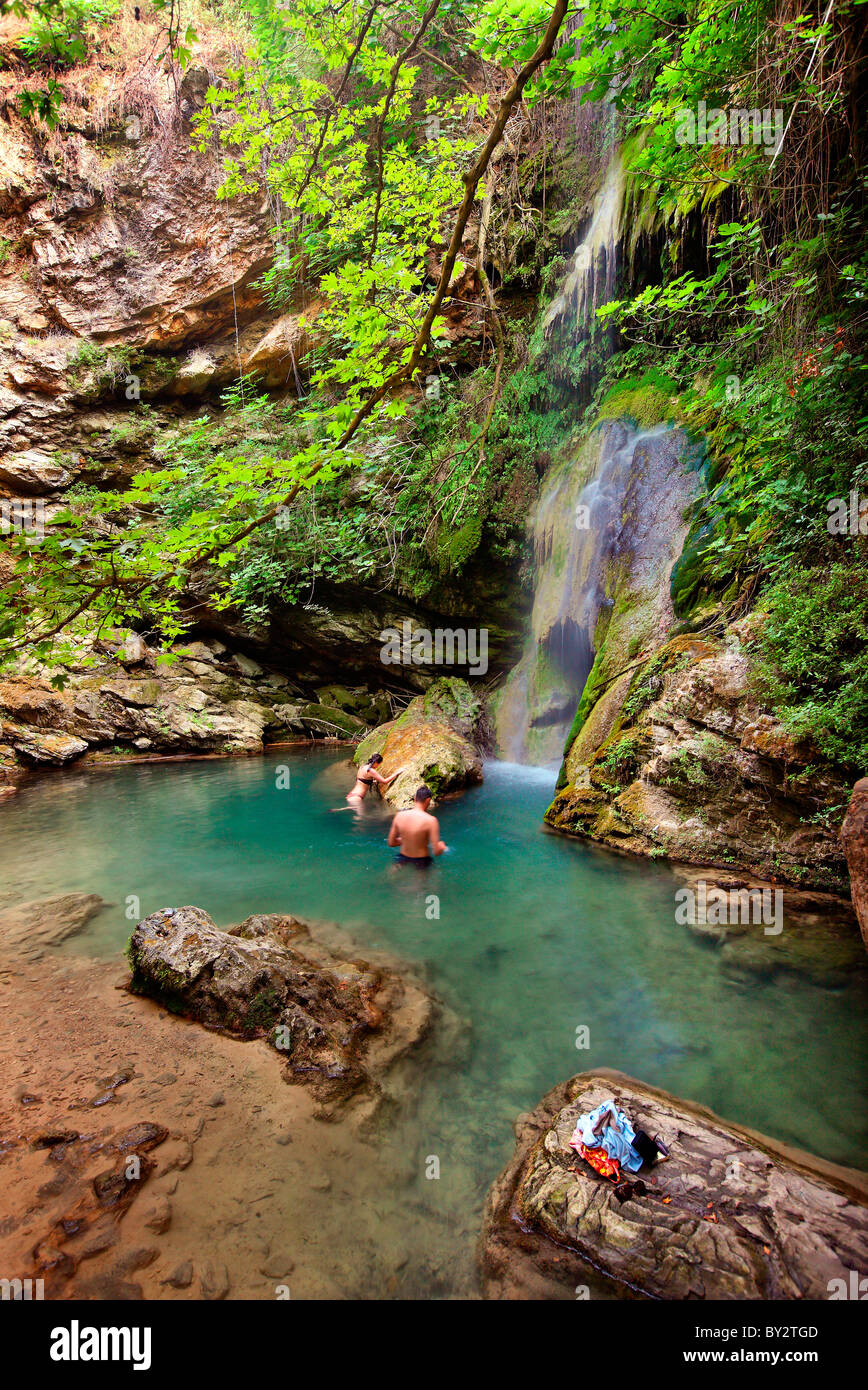La Grecia, Cythera (o 'Kithira') isola. Una giovane coppia di nuoto in 'Fonissa' cascata, vicino a Mylopotamos villaggio Foto Stock
