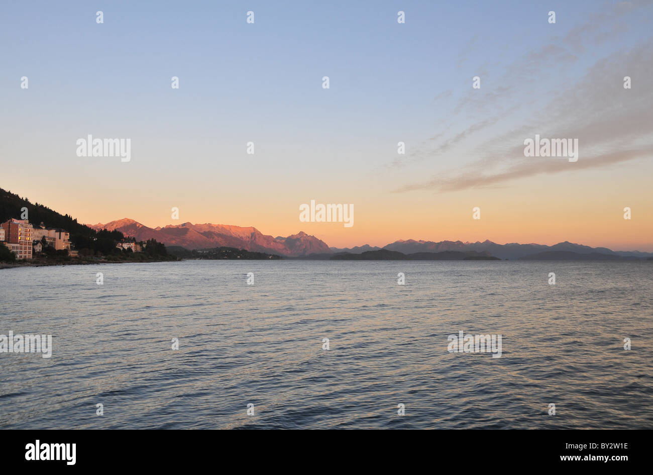 Cerro Lopez e picchi andini rosso incandescente nella luce del sole di mattina attraverso le acque del lago Nahuel Huapi, Bariloche waterfront, Argentina Foto Stock