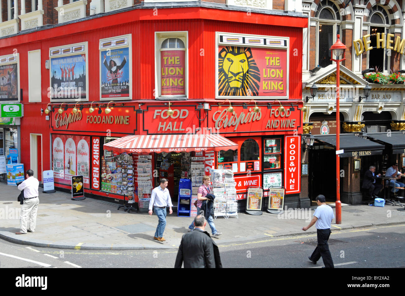 Scena di strada Crispins colorati cibo vino News & Bakery angolo hall negozio theatreland pubblicità in Shaftsbury Avenue Soho West End Londra Inghilterra Regno Unito Foto Stock