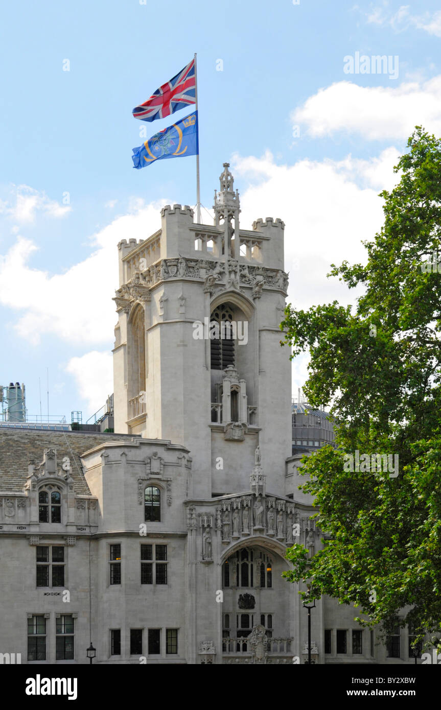 Union Jack & Emblem bandiere UKSC che volano sopra la torre di pietra del vecchio edificio Middlesex Guildhall ora Corte Suprema del Regno Unito in Parliament Square Londra Inghilterra Regno Unito Foto Stock