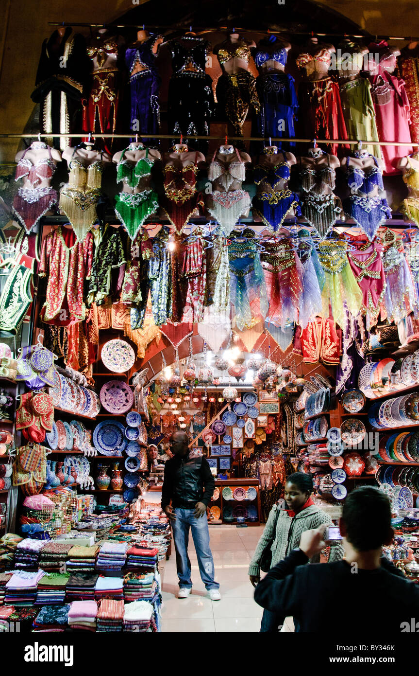 Negozio di souvenir del Bazaar delle spezie Istanbul Turchia // ISTANBUL, Turchia - Un negozio nel Bazaar delle spezie (noto anche come Bazaar egiziano) espone piatti colorati, costumi di danza del ventre e vari souvenir per i turisti. Il Bazar delle spezie, uno dei più antichi mercati coperti di Istanbul, fu costruito negli anni '1660 come parte del complesso della nuova Moschea. Situato nel quartiere di Eminönü, il bazar era originariamente un centro commerciale per spezie ed erbe medicinali importate dall'Egitto e dall'India. Oggi, il mercato ospita dozzine di negozi che vendono prodotti tradizionali turchi, spezie, dolci e merci turistiche. T Foto Stock