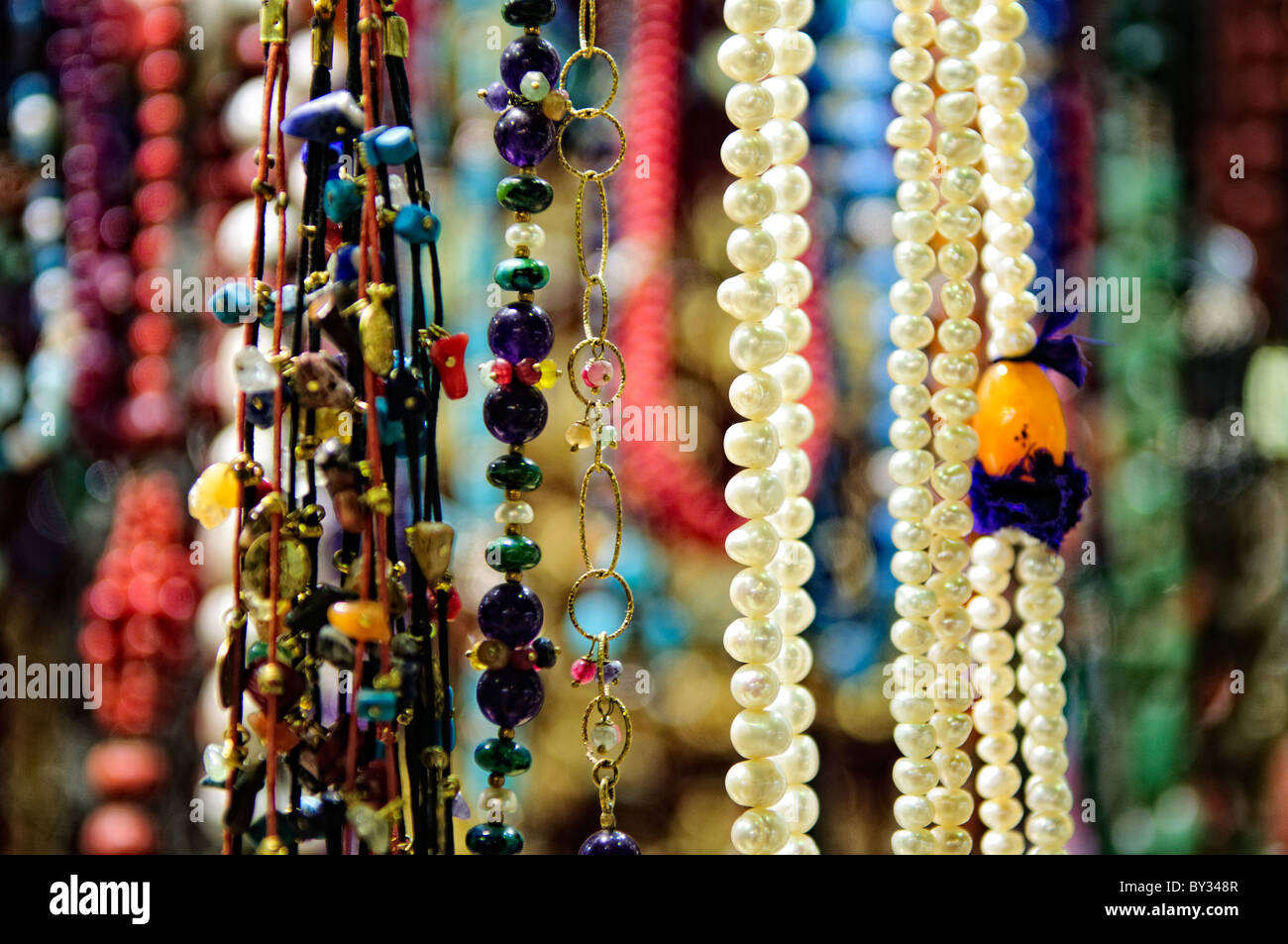 Gioielli e monili appendere sul display per la vendita in uno dei tanti piccoli negozi di Istanbul storica del Grand Bazaar, la profondità di campo. Foto Stock