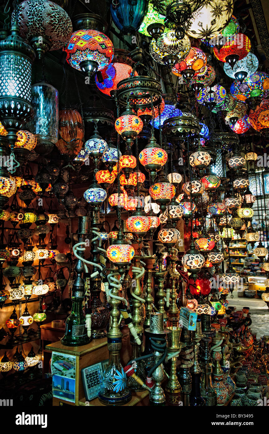 ISTANBUL, Turchia: Vivaci lampade in vetro a mosaico illuminano un negozio nello storico Grand Bazaar di Istanbul. La gamma colorata di lampade tradizionali turche crea un'abbagliante esposizione di artigianato artigianale. Queste lampade distintive, che combinano vetro colorato e metallo, rappresentano uno dei molti mestieri tradizionali disponibili in questo mercato secolare. Foto Stock