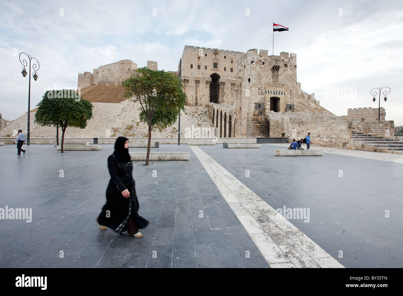 Una donna siriana passeggiate nella parte anteriore di Aleppo la cittadella in Siria - - al mattino presto prima che la solita folla di turisti Foto Stock