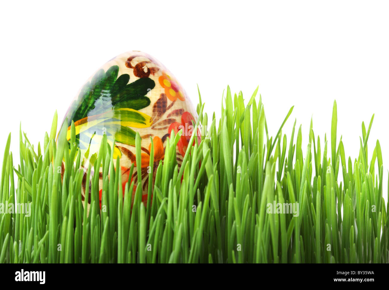 Uovo di Pasqua in erba verde isolato su sfondo bianco Foto Stock