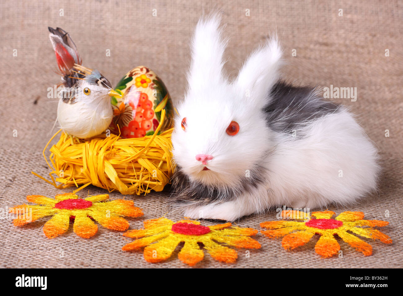 Carino bunny e uovo di pasqua nel nido su saccheggi sullo sfondo Foto Stock