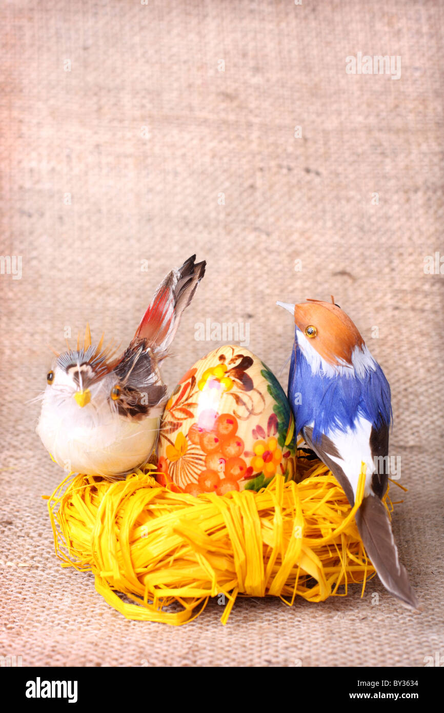 Uovo di Pasqua e di uccelli nel nido su saccheggi sullo sfondo Foto Stock