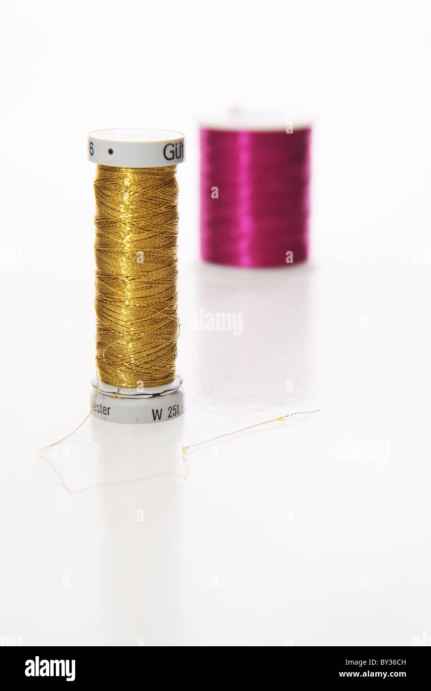 Oro e porpora di filato su sfondo bianco Foto Stock