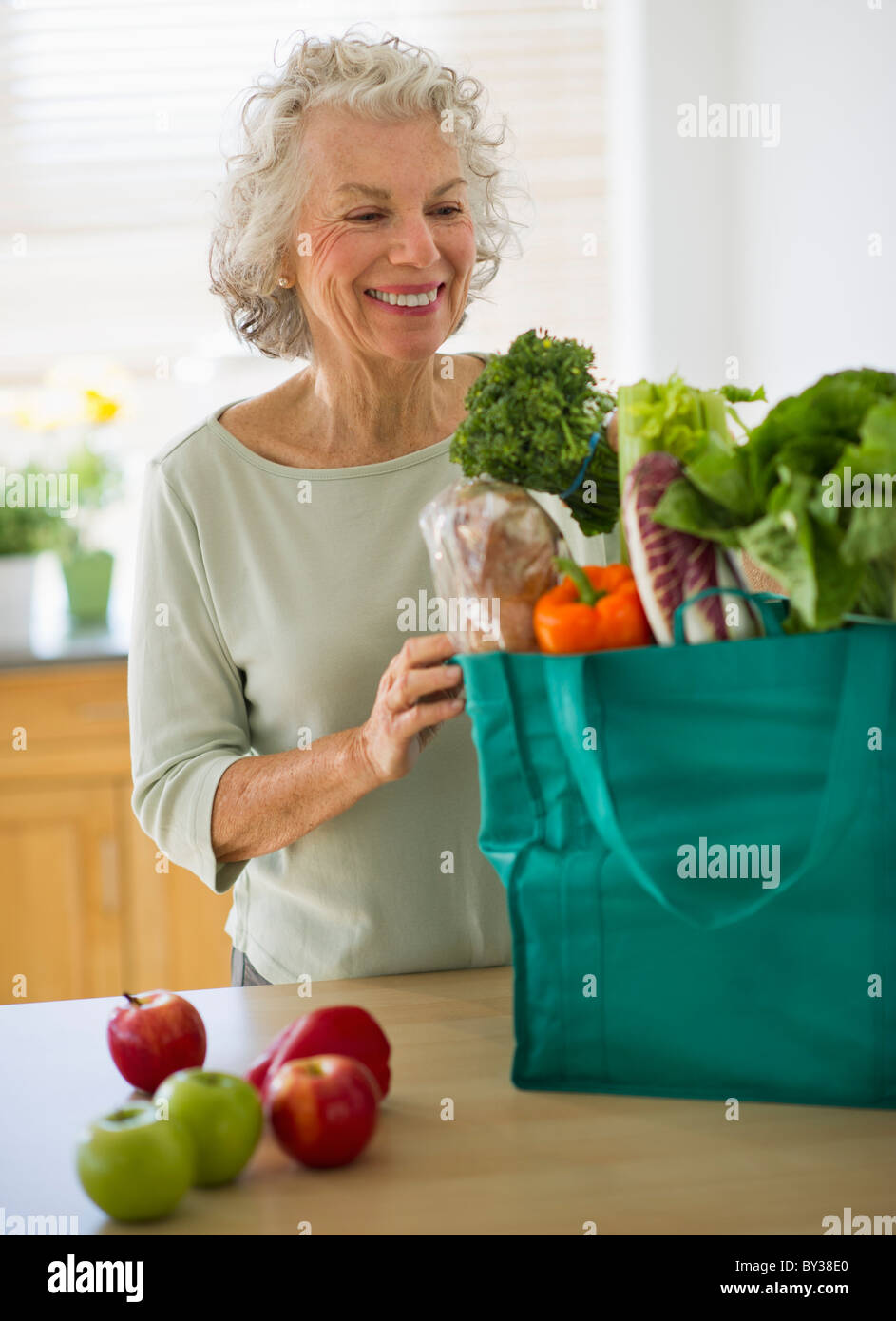 Stati Uniti d'America, New Jersey, Jersey City, Senior donna con sacchetto shopper in cucina Foto Stock