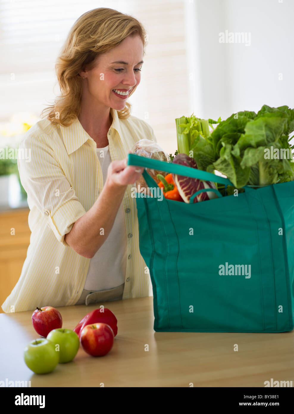 Stati Uniti d'America, New Jersey, Jersey City, Donna con sacchetto shopper in cucina Foto Stock