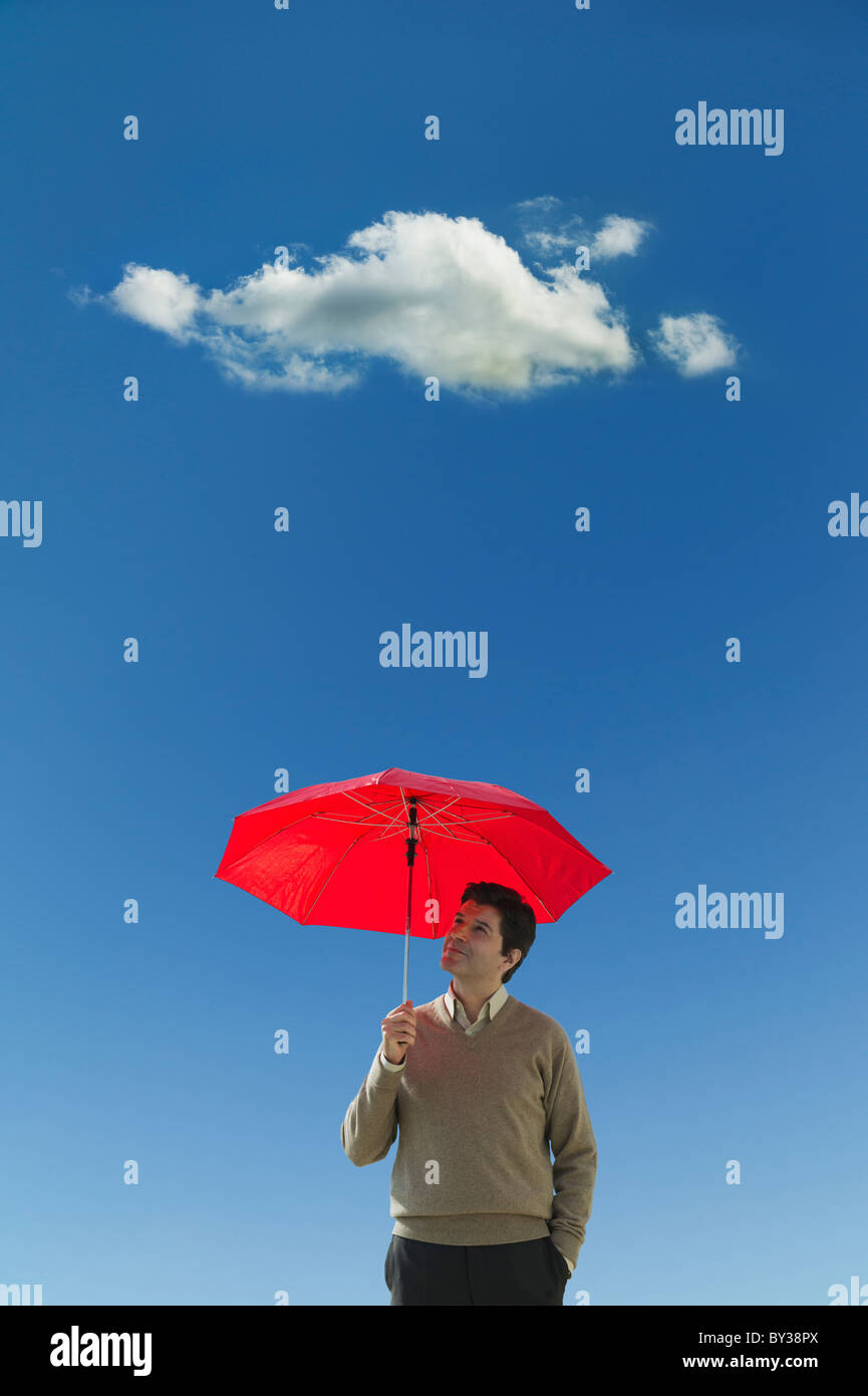 Uomo con ombrello sotto il cloud Foto Stock