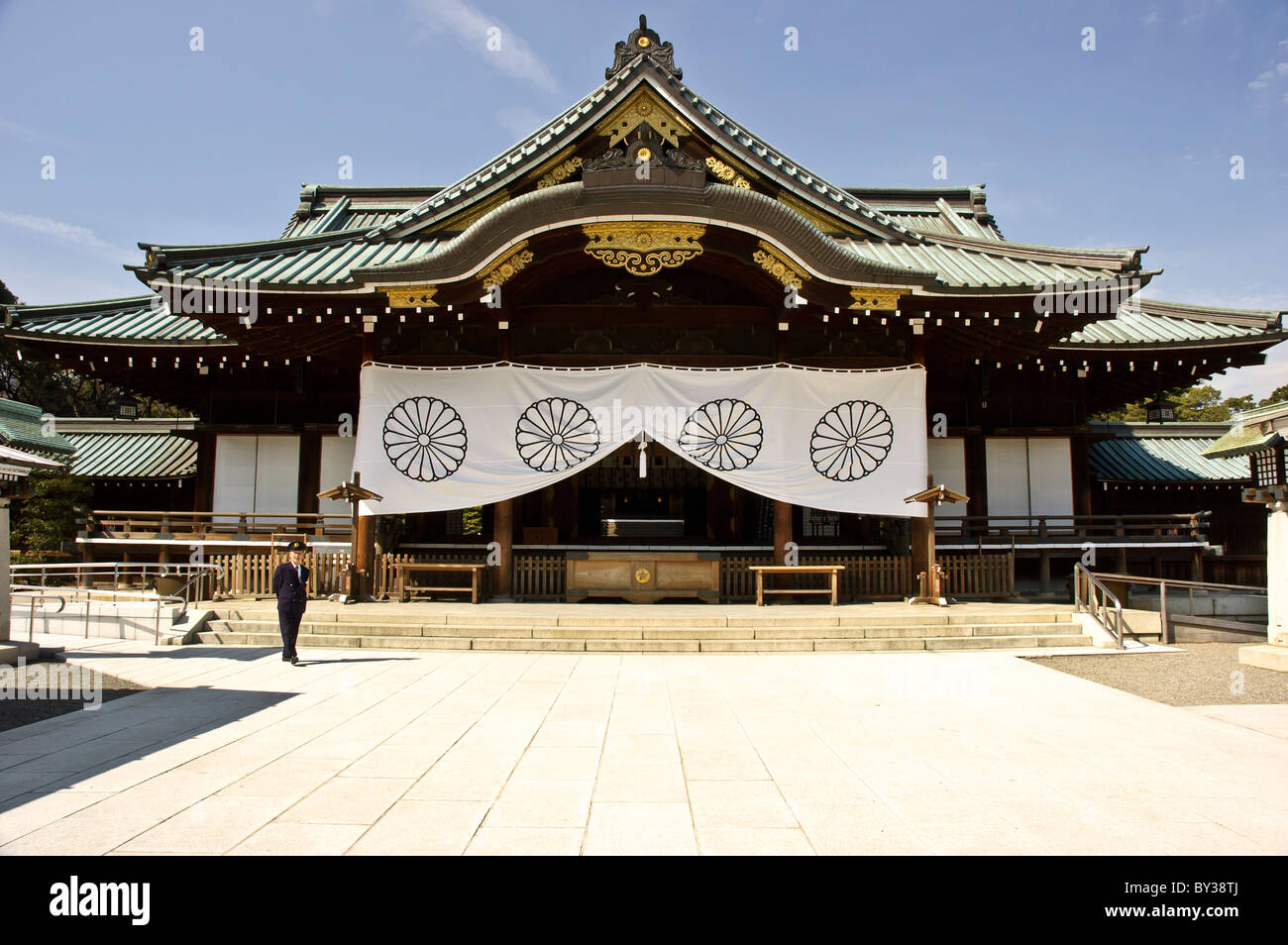 La sala principale (Haiden) di Yasukuni sacrario scintoista, Tokyo, Giappone. Di fronte si erge una guardia di sicurezza. Foto Stock