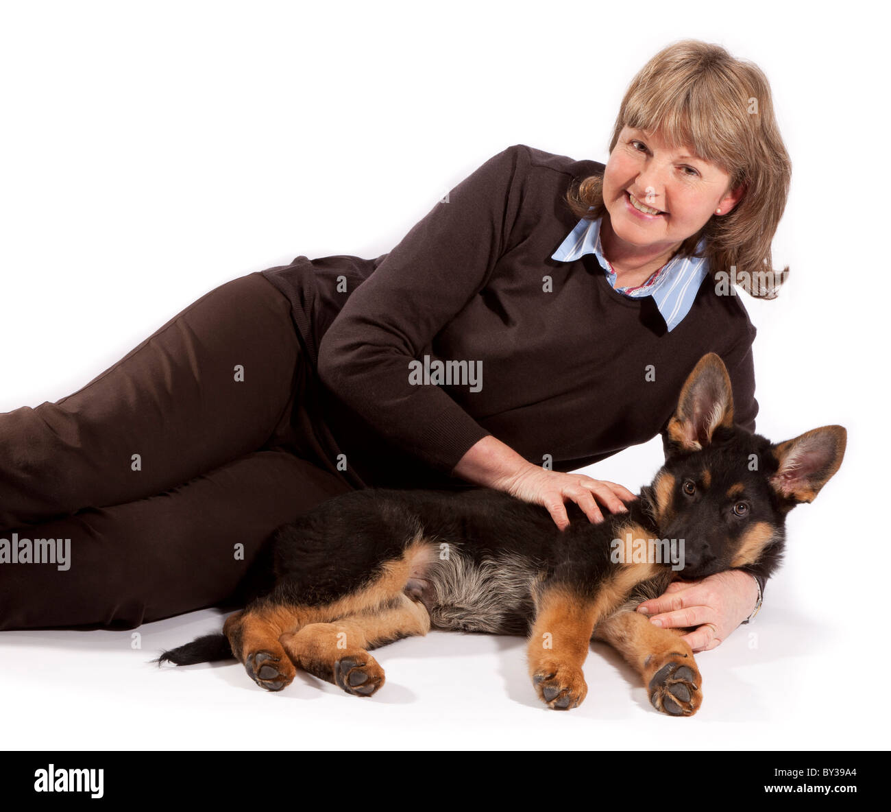 Una signora con un tredici settimane vecchio pastore tedesco cucciolo di cane Foto Stock