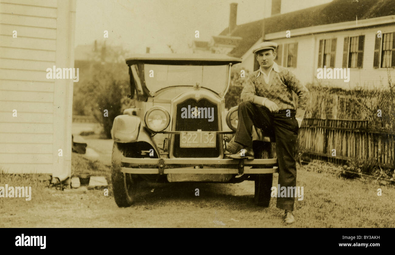 Circa 1930 fotografia di un orgoglioso uomo, piede sul paraurti della sua vettura. Foto Stock