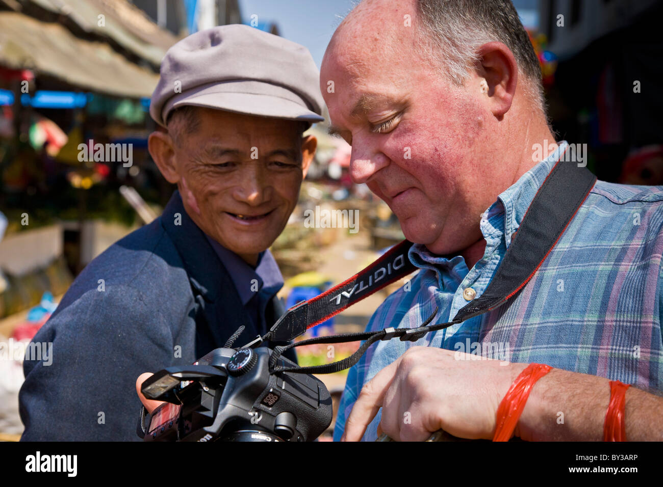 Turistica Locale e uomo a produrre Menghai mercato, nella provincia dello Yunnan, Regione di Xishuangbanna, Repubblica Popolare Cinese. JMH4192 Foto Stock