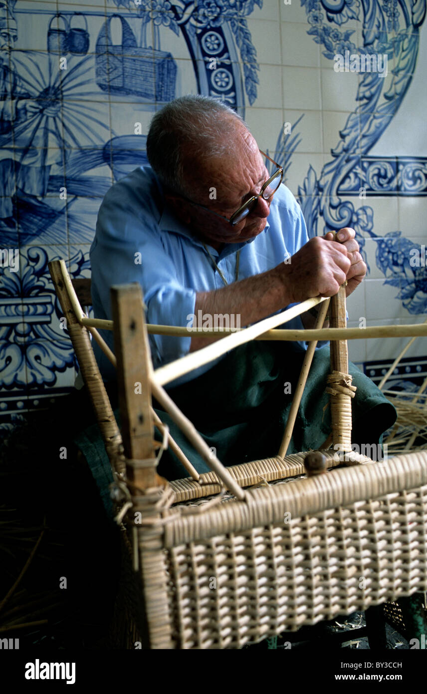Un locale maschi anziani artigianale di realizzare una sedia di vimini in un workshop nei pressi di Furnas nelle Azzorre Foto Stock