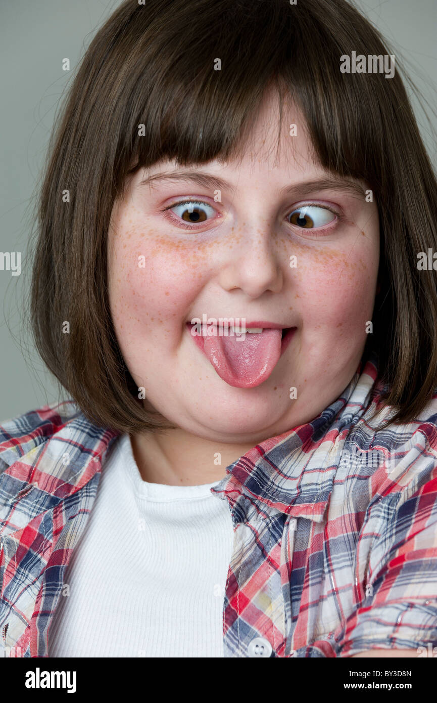 Close up ritratto di Giovane ragazza con la lingua fuori e attraversato gli occhi e con lunghezza di spalla marrone capelli Foto Stock