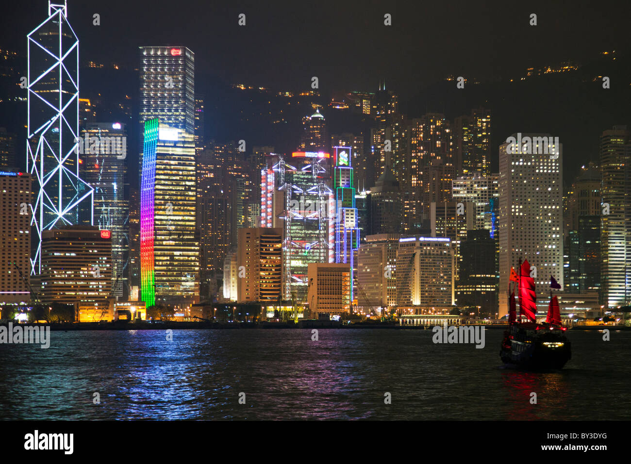 Isola di Hong Kong Cina skyline della città del quartiere centrale di notte come si vede attraverso il Victoria Harbour da Kowloon Foto Stock