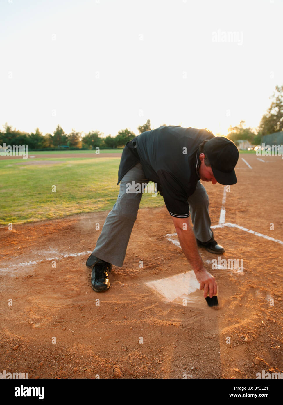 Stati Uniti, California, Ladera Ranch, uomo disegno in sabbia sul diamante di baseball Foto Stock