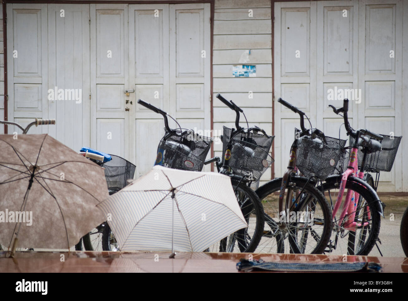 Biciclette Parcheggio di fronte a una casa in un giorno di pioggia nella città vecchia di Chiang Khan, Loei Foto Stock