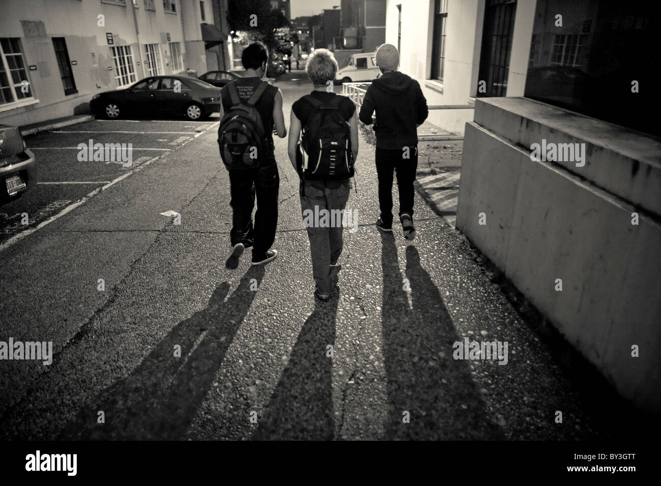 Senzatetto i giovani adulti a piedi attraverso un vicolo sul loro modo di un ricovero per senzatetto a Seattle il quartiere universitario Foto Stock