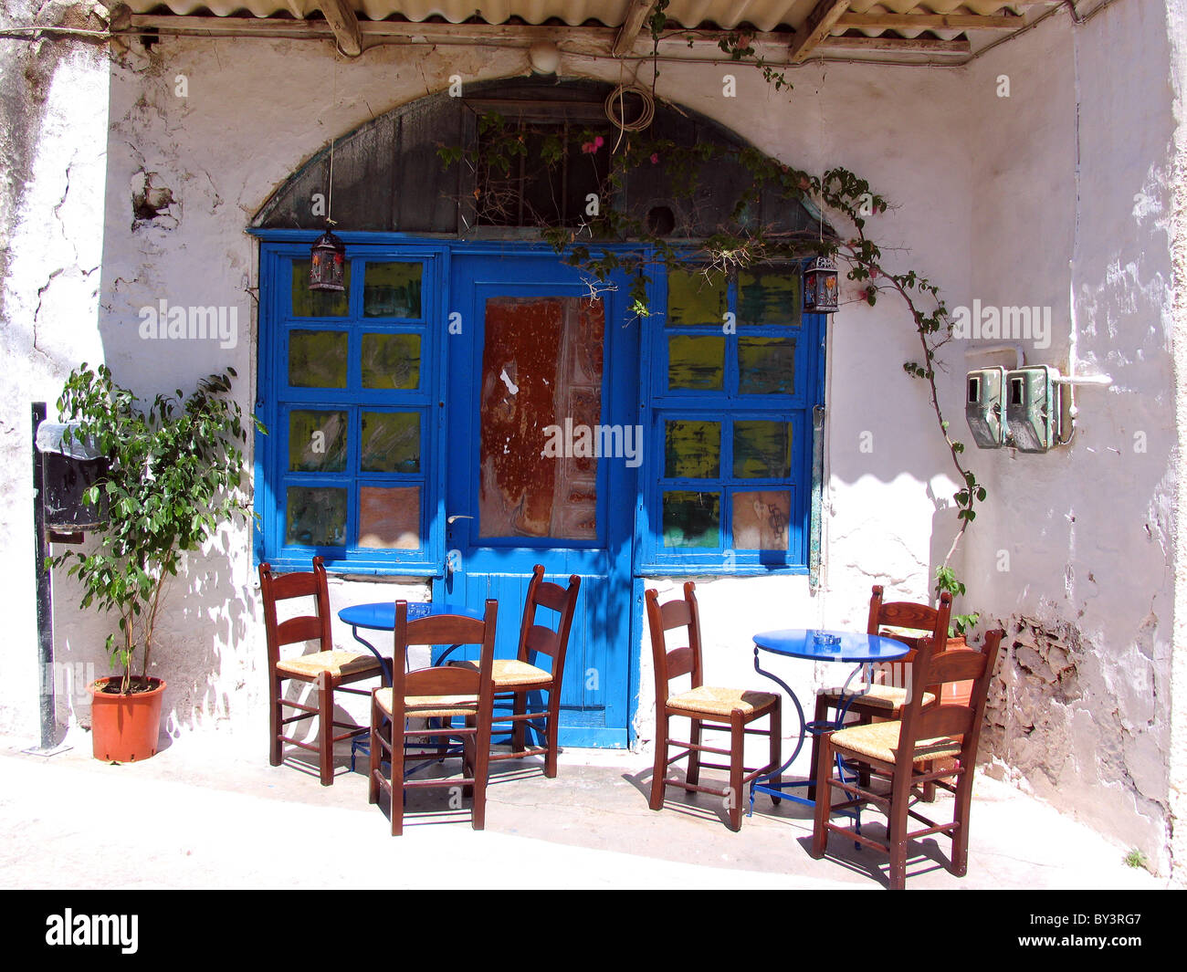 Tipicamente greco porta blu e sedie e tavolo presso la cittadina collinare di Parga sulla costa occidentale della Grecia Foto Stock