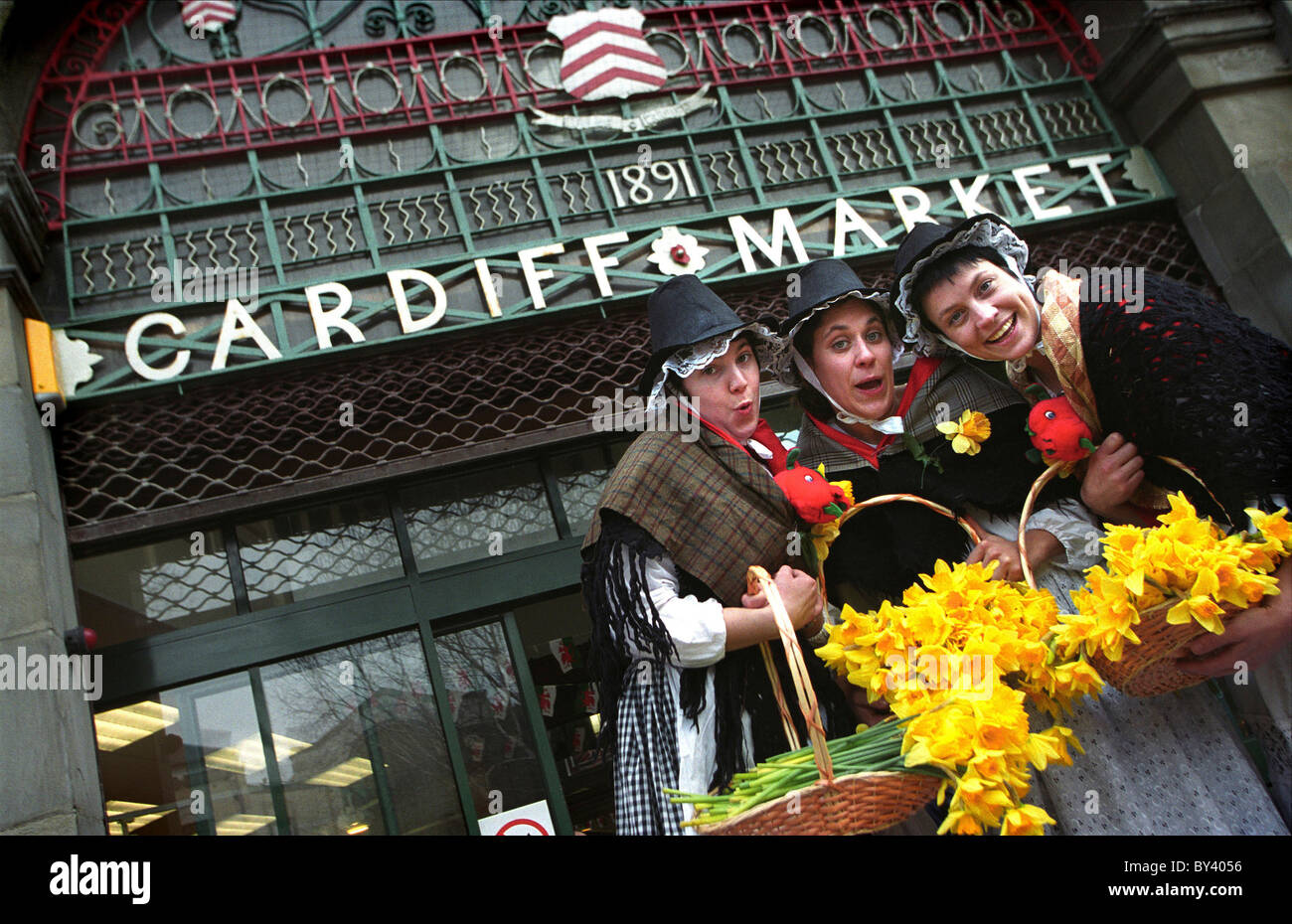 Welsh Ladies dando dei narcisi a Cardiff mercato il giorno di San Davide. Foto Stock