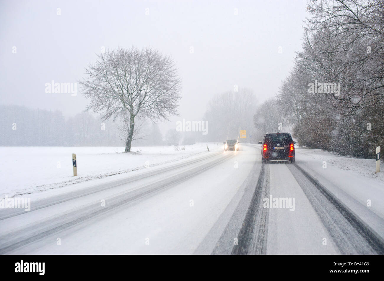 Condizioni di strada inverno inverno street visto dal finestrino di una macchina carwindow snow nevicare strada ghiacciata di ghiaccio coperto coprire Foto Stock