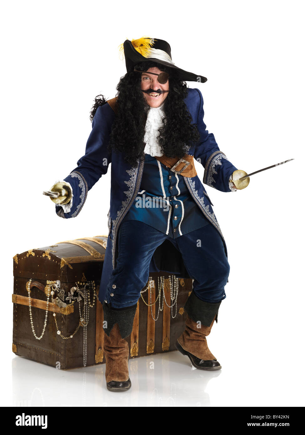 Licenza e stampe a MaximImages.com - pirata laughing con una spada e un gancio che protegge il suo scrigno pieno d'oro. Isolato su sfondo bianco Foto Stock