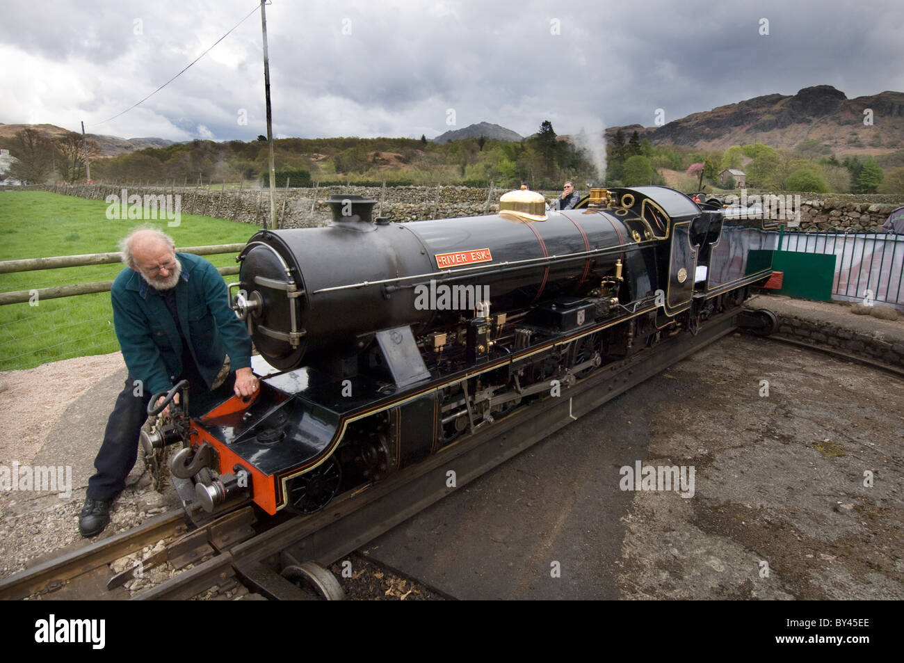 Il driver di 15 pollici manometro a scartamento ridotto locomotiva a vapore 'fiume Esk' utilizza la piattaforma girevole a Ravenglass per girare il suo motore round Foto Stock