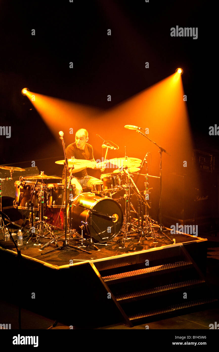 Il batterista in rock and roll band sul palco sotto bianco faretti in Austin, Texas. Prima di quattro in serie Foto Stock